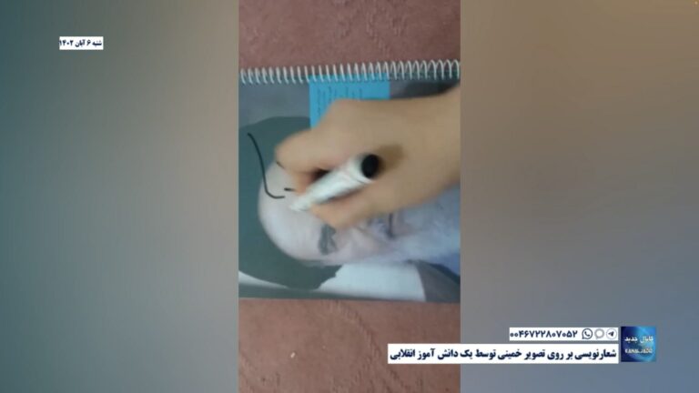 شعارنویسی بر روی تصویر خمینی توسط یک دانش آموز انقلابی