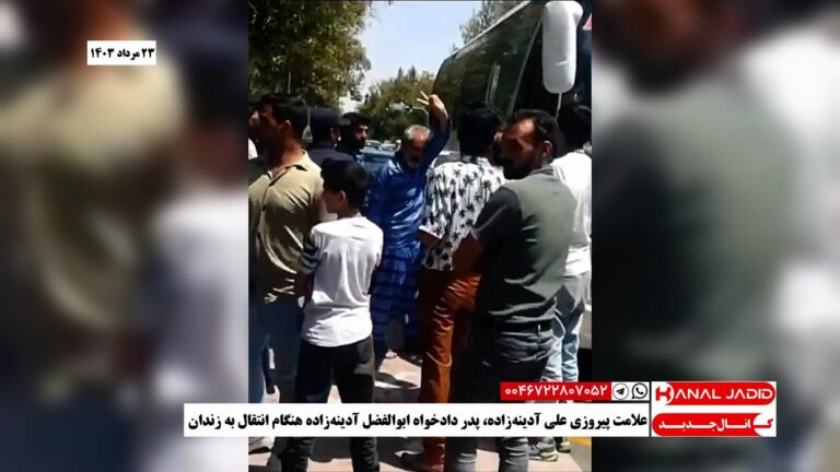 علامت پیروزی علی آدینه‌زاده، پدر دادخواه ابوالفضل آدینه‌زاده هنگام انتقال به زندان
